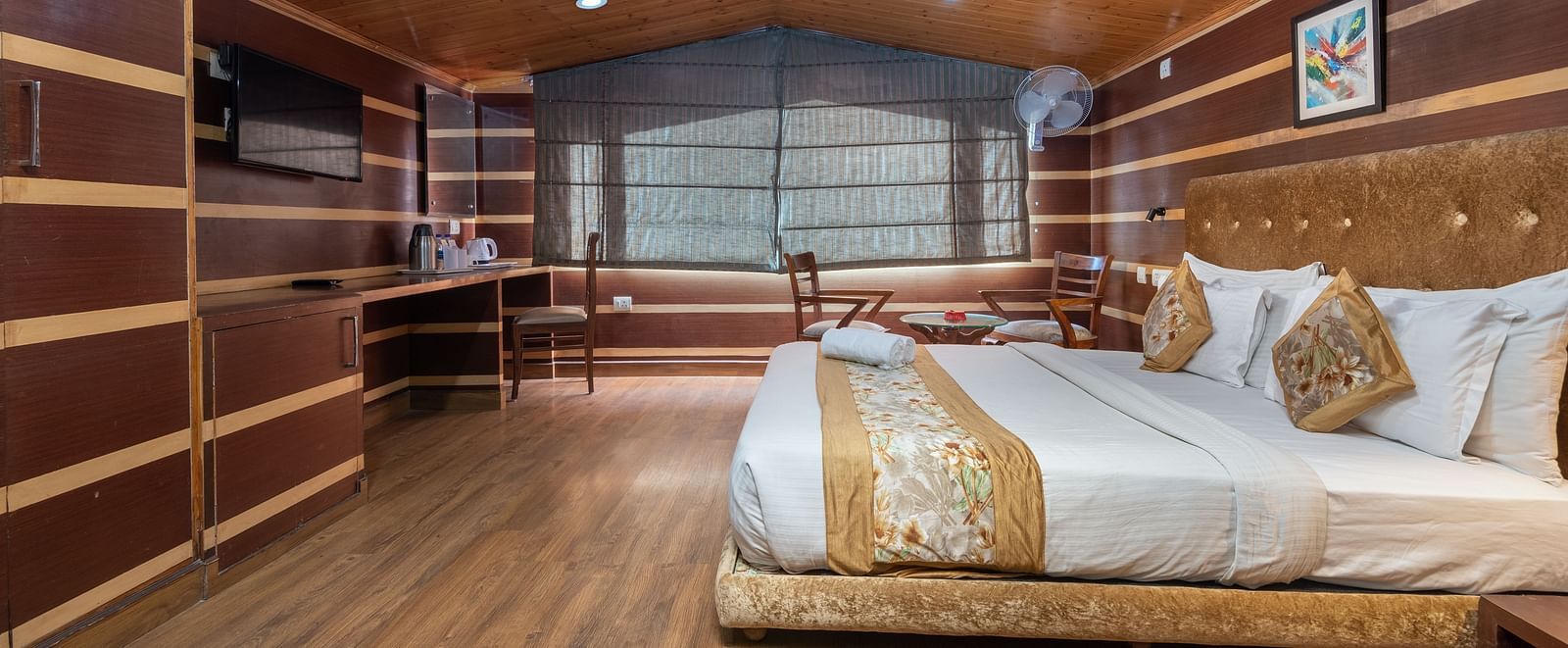 A bedroom with a sheer curtain covered  and a television